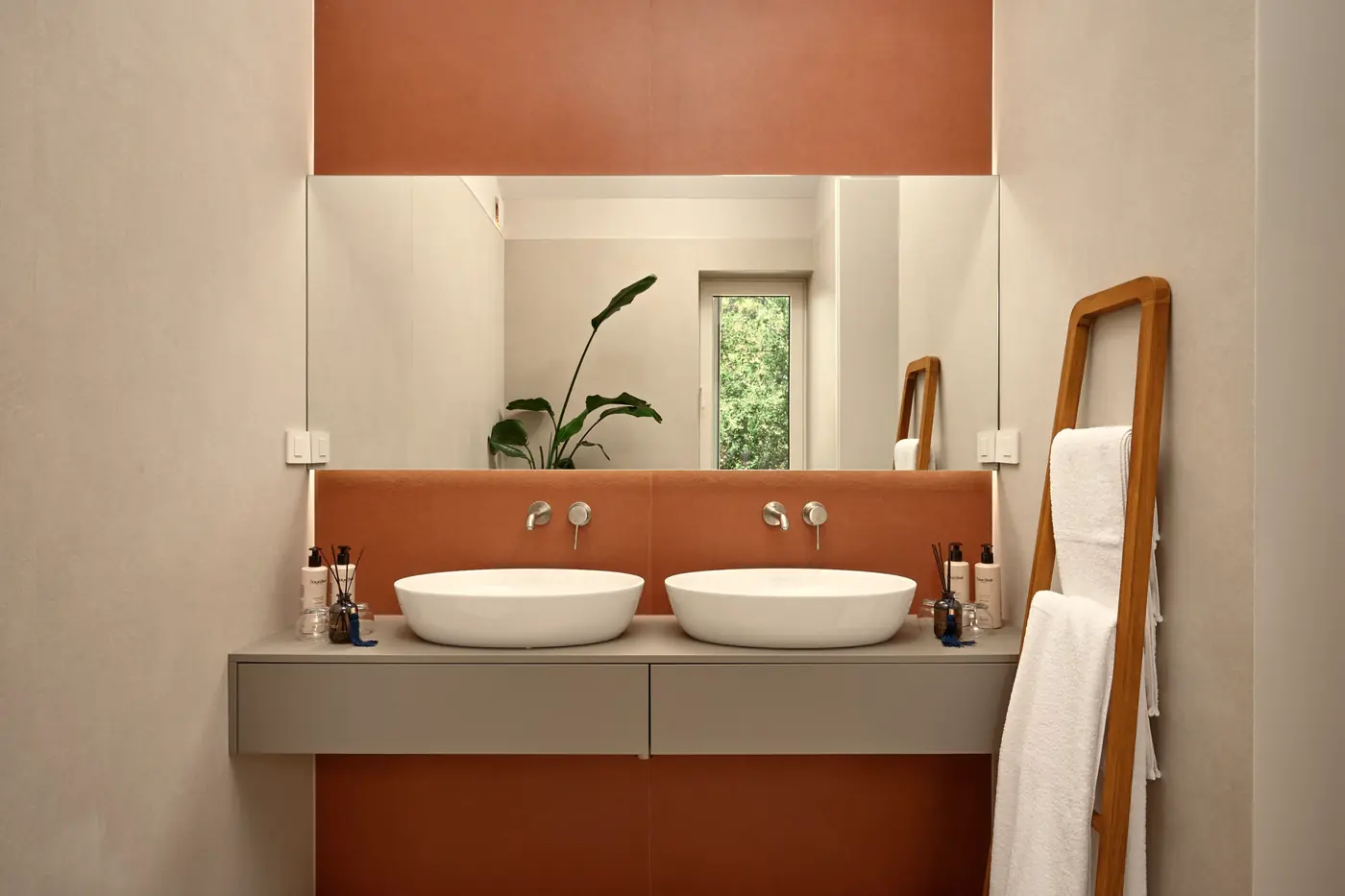Double basins against terracotta tile and a mirror