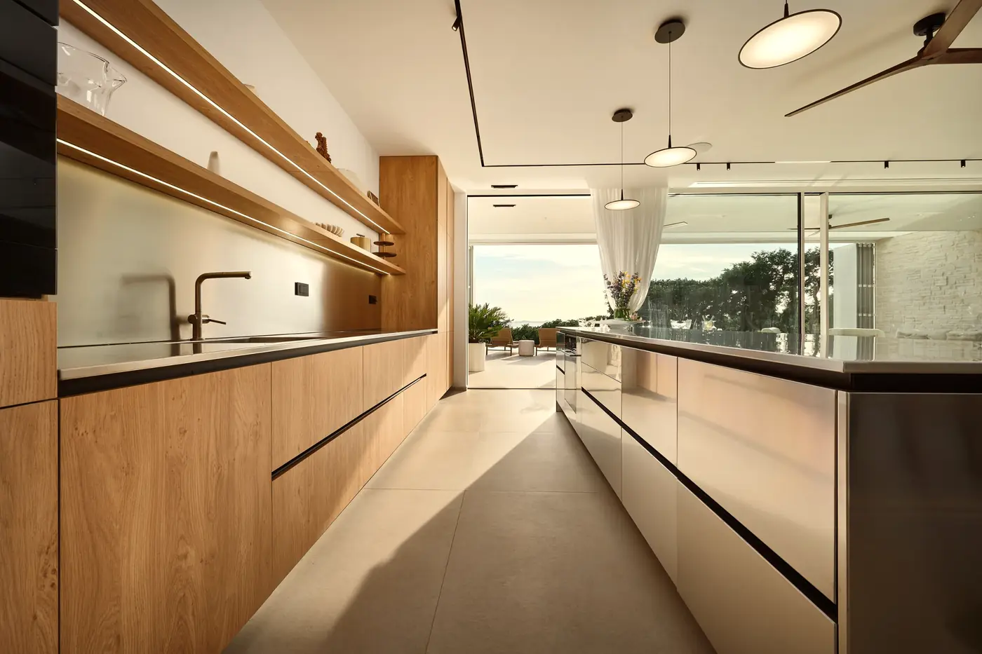 The kitchen in oak and steel, opening to the terrace